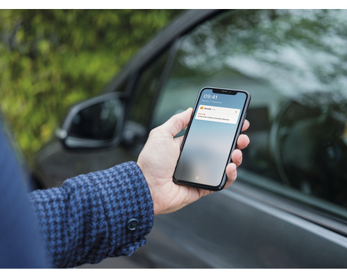 O persoană ține un smartphone cu o avertizare de securitate care indică o problemă cu monoxidul de carbon.