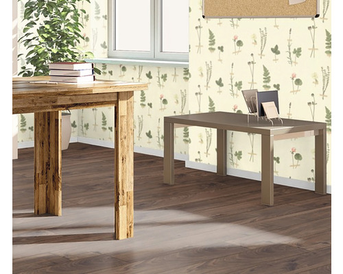 Vedere a unei camere cu masă din lemn, birou și tapet cu model floral