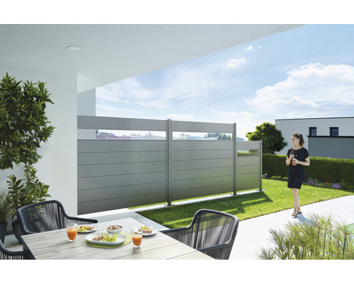 Terasa cu paravan de intimitate, masă și scaune în grădină.