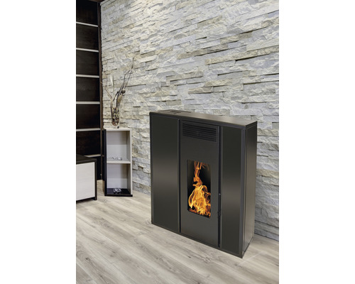 Șemineu negru pe peleți în camera de zi cu perete de piatră