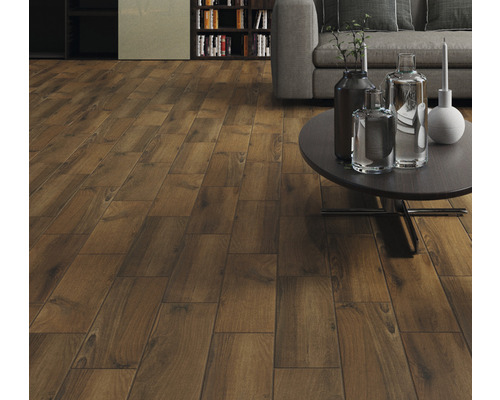 Living cu podea laminată cu aspect de lemn, completat de canapea și bibliotecă