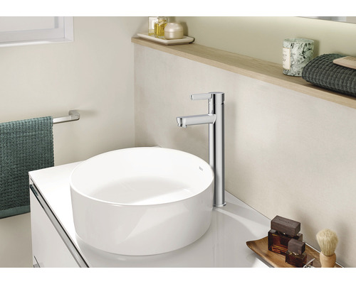 Baie modernă cu lavoar așezat pe blat, robinet și spațiu de depozitare.