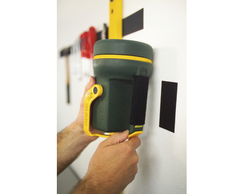 Unealtă multifuncțională verde cu închidere cu scai fixată pe un perete