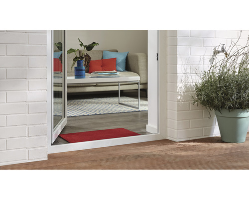 Scenă cu terasă exterioară, perete de cărămidă, plantă în ghiveci și vedere spre un living printr-o ușă de terasă