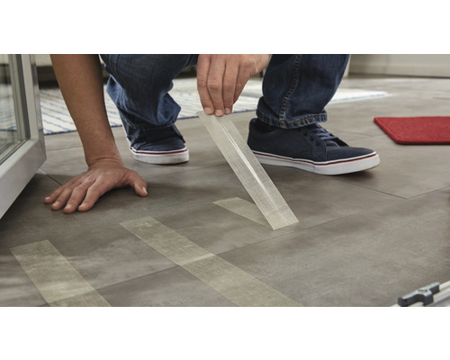 Bărbat care așează plăci cu bandă adezivă pentru fixare