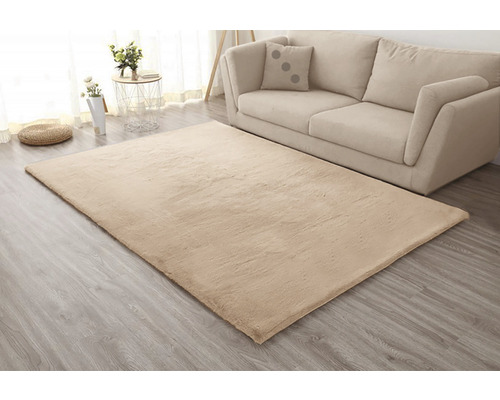 Covor bej în sufragerie lângă o canapea și o măsuță laterală.