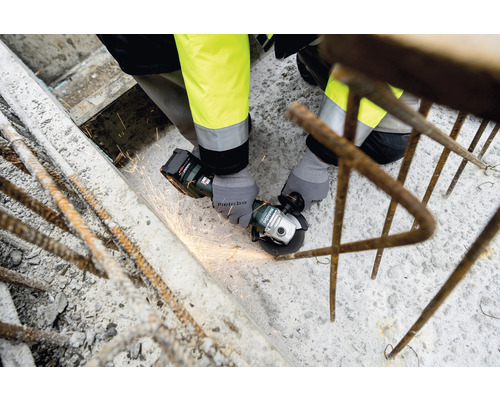 O persoană folosește un polizor unghiular cu acumulator Metabo pentru a șlefui metal.