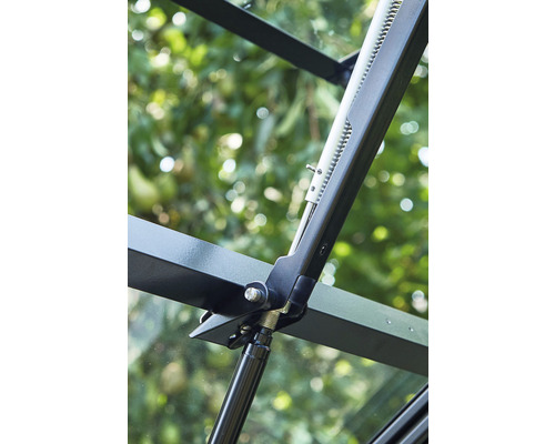 Prim-plan cu un deschizător de ferestre pe un geam de seră.