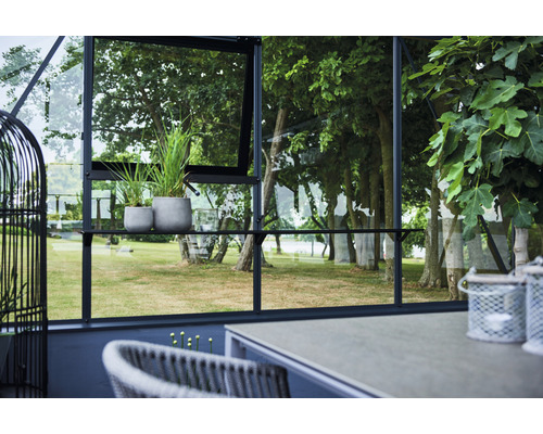 Vedere a unei sere cu plante, mese și scaune