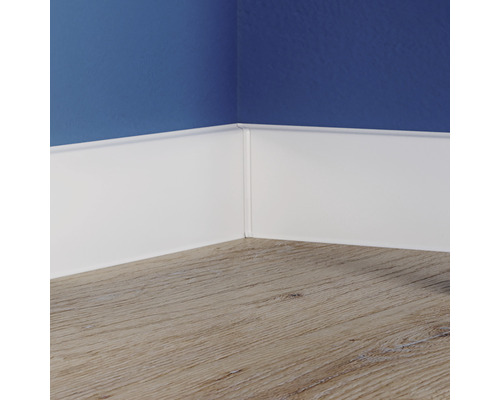 Plinte albe pe perete deasupra unei podele din lemn