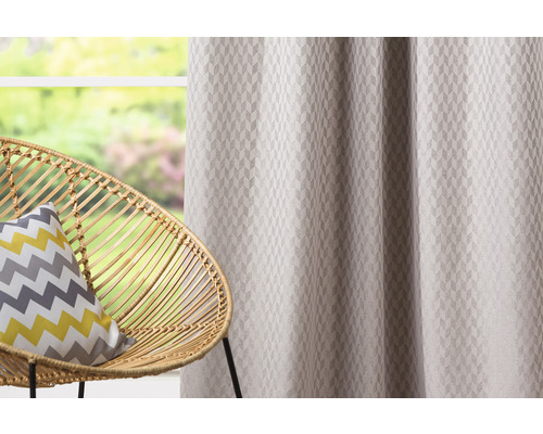 Șaluri decorative cu model geometric lângă un scaun de ratan