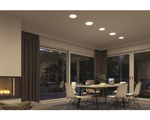 Cameră de zi cu spoturi încastrate, masă de sufragerie și șemineu