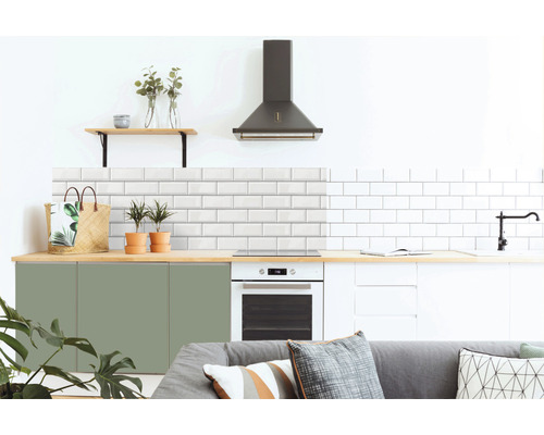 Bucătărie modernă cu faianță albă tip metro, dulapuri verzi și albe, hotă și elemente din lemn.
