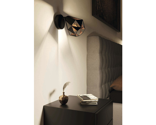 Lampa de perete metalică în dormitor deasupra unei noptiere