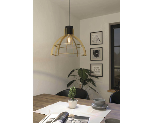 Lampa suspendată metalică deasupra unei mese de sufragerie