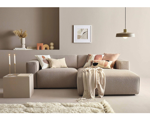 Cameră de zi cu canapea de colț, măsuță de cafea, covor și decorațiuni