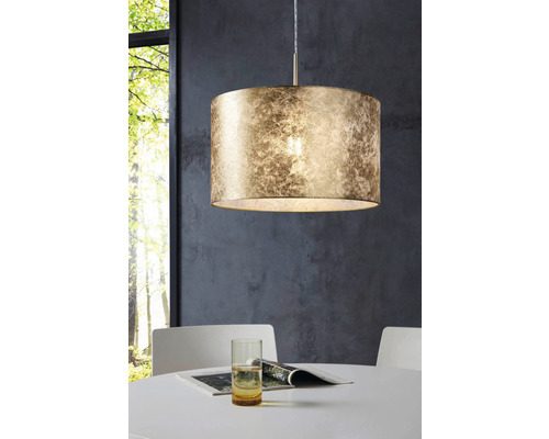 Lampa suspendată cu abajur rotund deasupra unei mese de sufragerie.