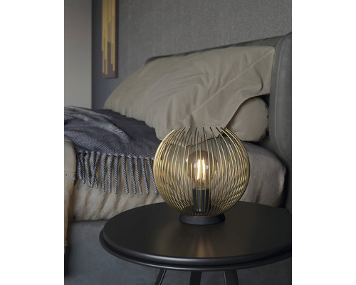 Lampă de masă decorativă cu abajur sferic din sârmă pe o noptieră