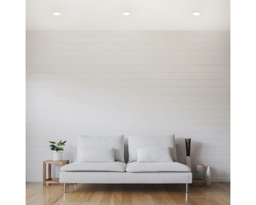 Cameră de zi luminoasă cu canapea, plantă de interior și spoturi încastrate în tavan