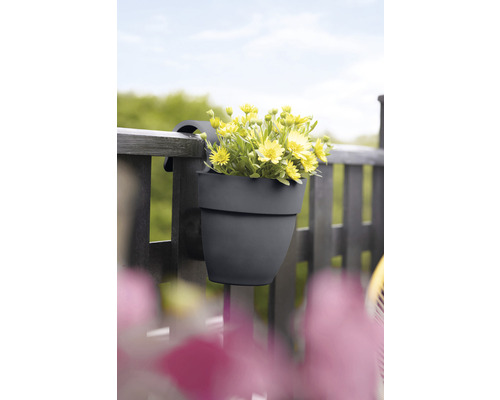 Jardinieră de balcon gri cu flori galbene pe balustradă