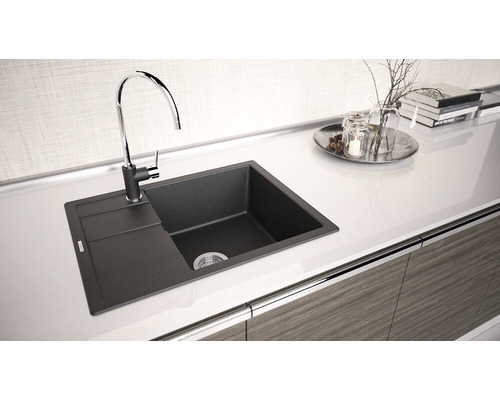 Chiuvetă de bucătărie din granit cu zonă de scurgere și baterie pe un blat.