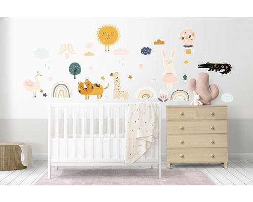 Cameră de copii cu pătuț, comodă și autocolante de perete cu motive de animale, cum ar fi soare, girafă, tigru și crocodil.