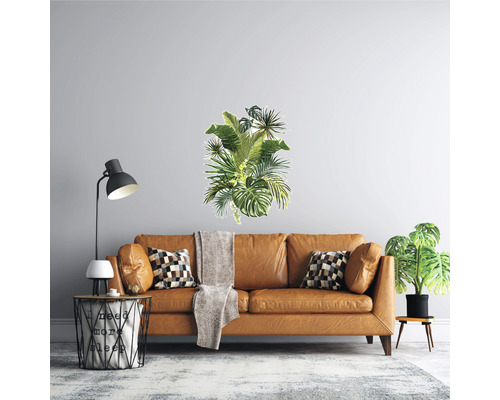 Sufragerie cu canapea maro, lampadar și autocolant de perete cu frunze tropicale