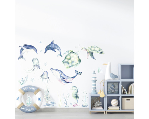 Decor de perete cu autocolante cu animale marine într-o cameră de copii, inclusiv delfini, broaște țestoase, balene și o geamandură cu inscripția Bine ați venit la bord
