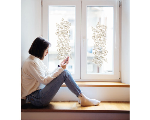 Femeie stând pe pervazul ferestrei cu folie decorativă cu flori aplicată pe geam