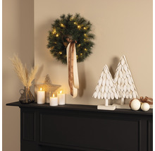 Aranjament decorativ cu coroniță, lumânări LED și pomi decorativi pe un șemineu