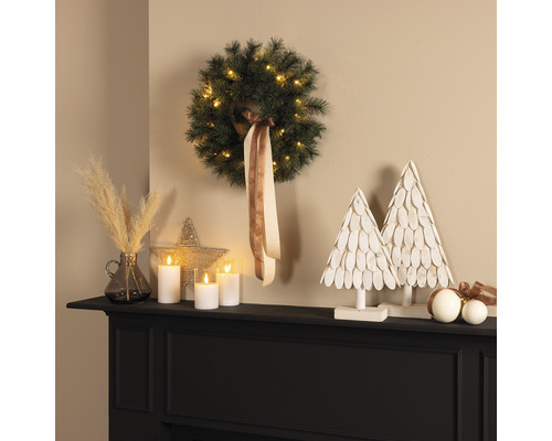 Aranjament decorativ cu coroniță, lumânări LED și pomi decorativi pe un șemineu