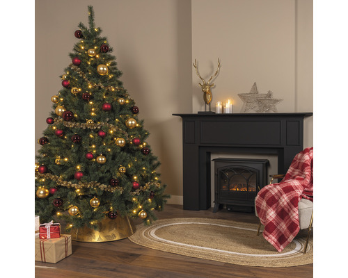 Cameră de zi decorată de Crăciun cu brad, șemineu și decorațiuni.