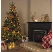 Brad împodobit festiv într-un living cu șemineu și cadouri.