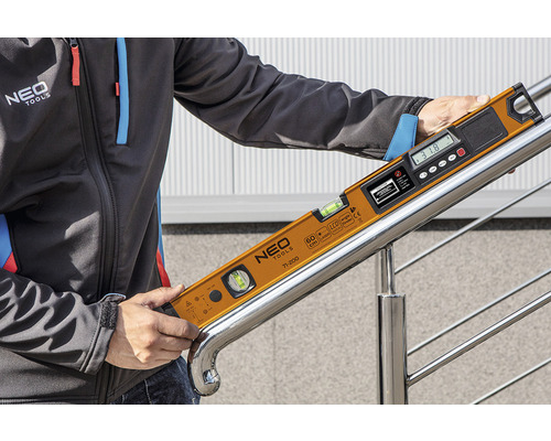 O persoană ține un nivel digital cu bulă de aer marca Neo Tools pe o balustradă de scară.