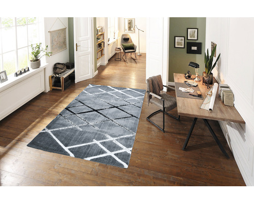 Scenă de living cu covor gri cu model geometric pe podea de lemn