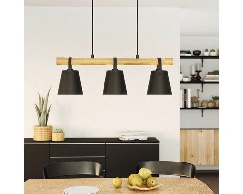 Lumină suspendată cu trei lămpi și detaliu din lemn deasupra unei mese de sufragerie