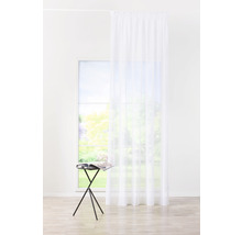 Vedere într-o cameră luminoasă cu o draperie albă transparentă în fața unei ferestre