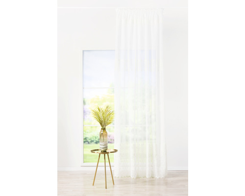 Scenă cu o draperie albă transparentă în fața unei ferestre, o măsuță laterală și o vază cu decorațiuni