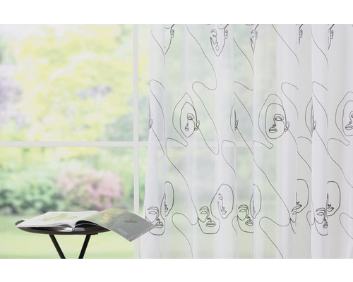 Șaluri decorative cu modele de fețe în fața unei ferestre