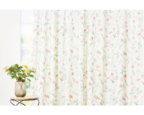 Cortină cu model floral în fața unei ferestre