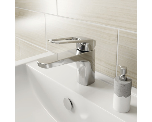 Baterie de lavoar lucioasă pe o chiuvetă cu dispenser de săpun.