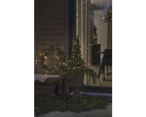 Verandă decorată cu coroană luminoasă și pom în vas