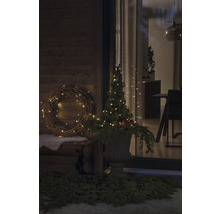 Scenă exterioară decorată cu coroană, pom iluminat și decorațiuni