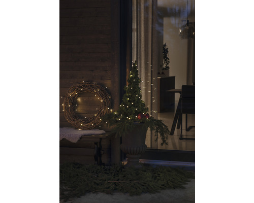 Scenă exterioară decorată cu coroană, pom iluminat și decorațiuni
