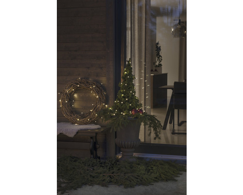 Verandă decorată cu coroană, pom iluminat și jardinieră