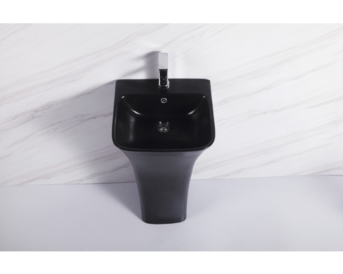 Lavoar negru pe piedestal cu robinet în fața unui perete de marmură