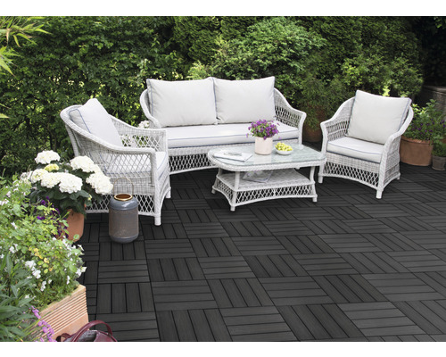 Terasa cu plăci de terasă întunecate și grup de relaxare din ratan în grădină