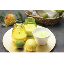 Aranjament decorativ cu lumânări parfumate, lămâie și lime pe o farfurie aurie.