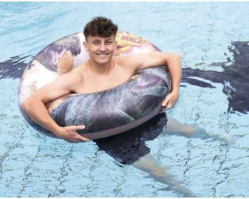 O persoană înoată cu o colac de înot Jurassic World în piscină.