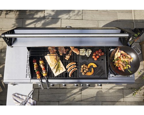 Vedere de sus a unui grătar pe gaz cu carne, legume și fructe de mare.